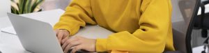 Main posée sur un bureau, manche jaune visible