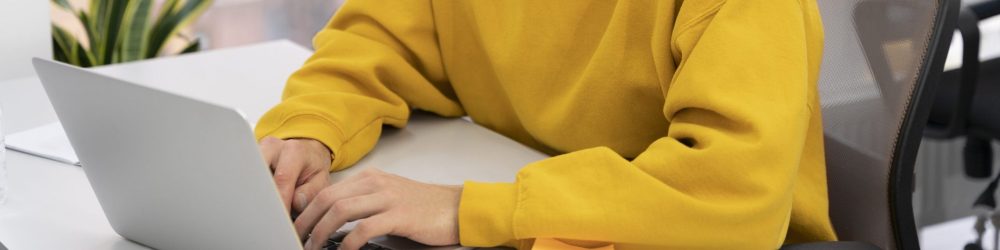 Main posée sur un bureau, manche jaune visible